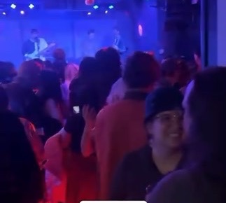 The crowd at Pianos facing the stage while Darksoft plays under blue lights
